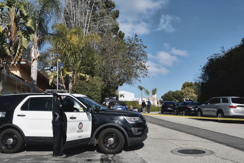 La policía acordona la calle en donde tres personas murieron y cuatro más resultaron heridas en un tiroteo en una casa en un exclusivo vecindario de Los Ángeles, el sábado 28 de enero de 2023. (AP Foto/Richard Vogel)