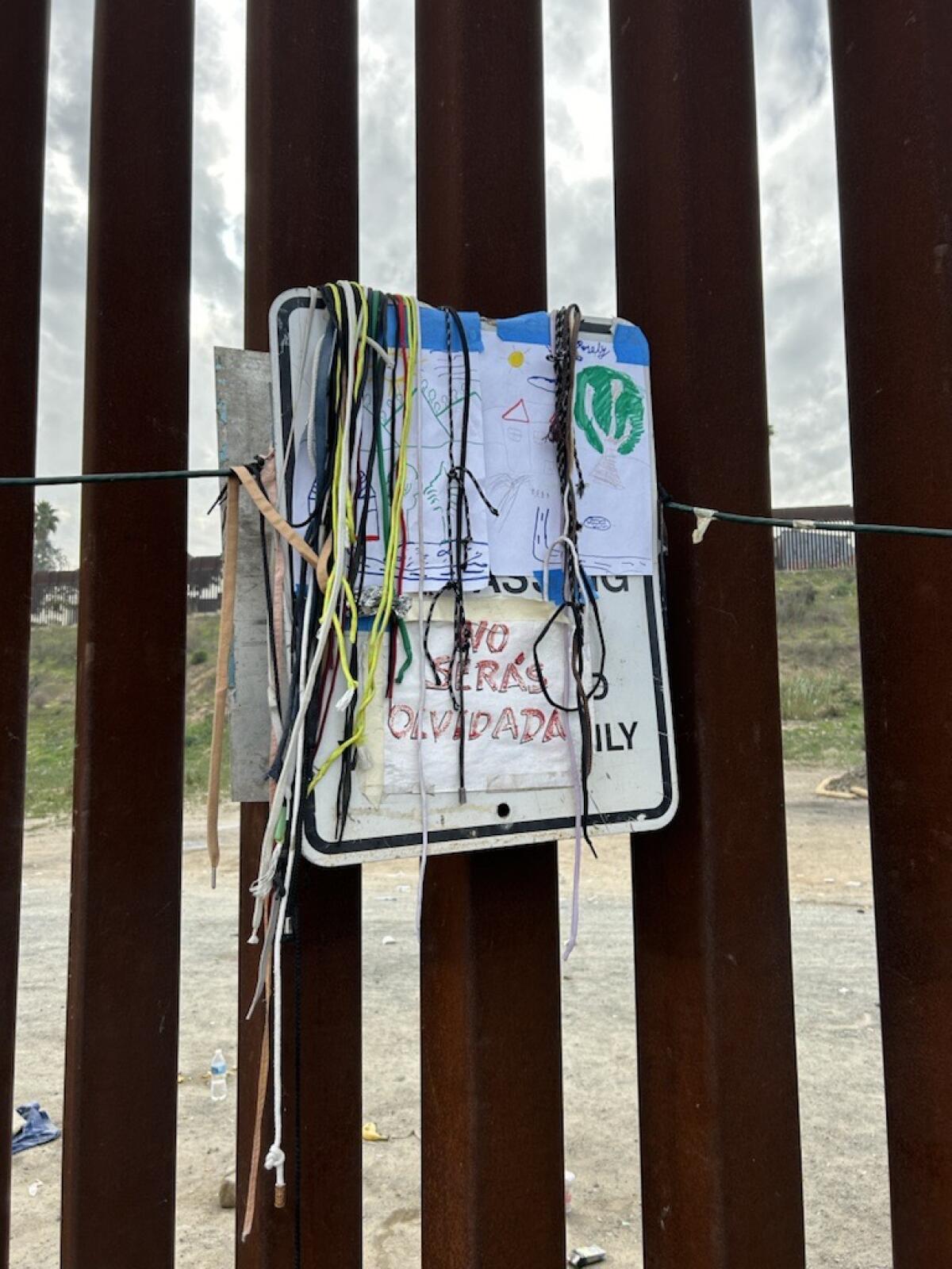 Shoelaces left behind by asylum seekers hang from a sign that reads: "U.S. property, no trespassing."