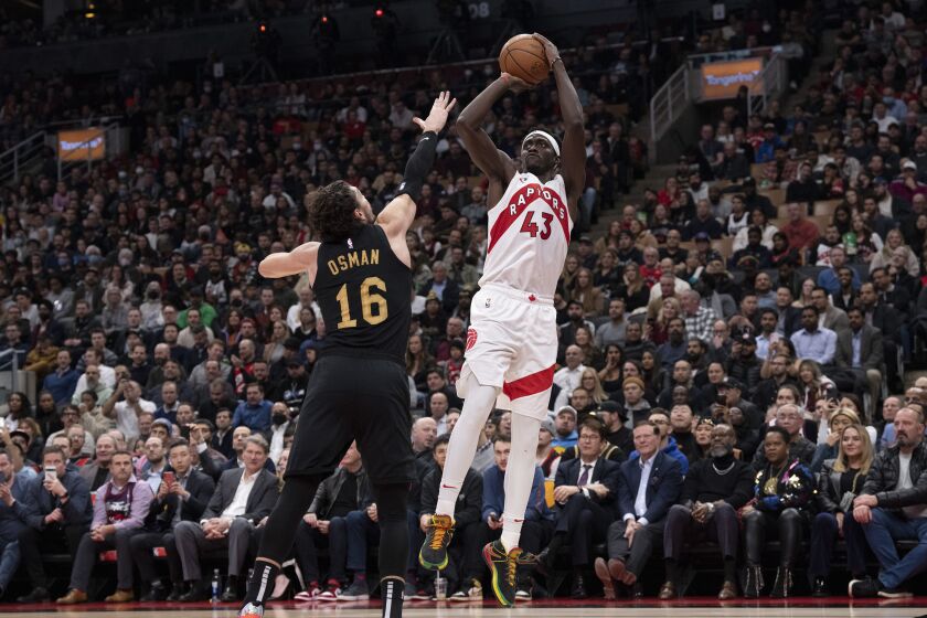 Pascal Siakam de los Raptors de Toronto anota superando a Cedi Osman de los Cavaliers de Cleveland en el encuentro del lunes 28 de noviembre del 2022. (Chris Young/The Canadian Press via AP)