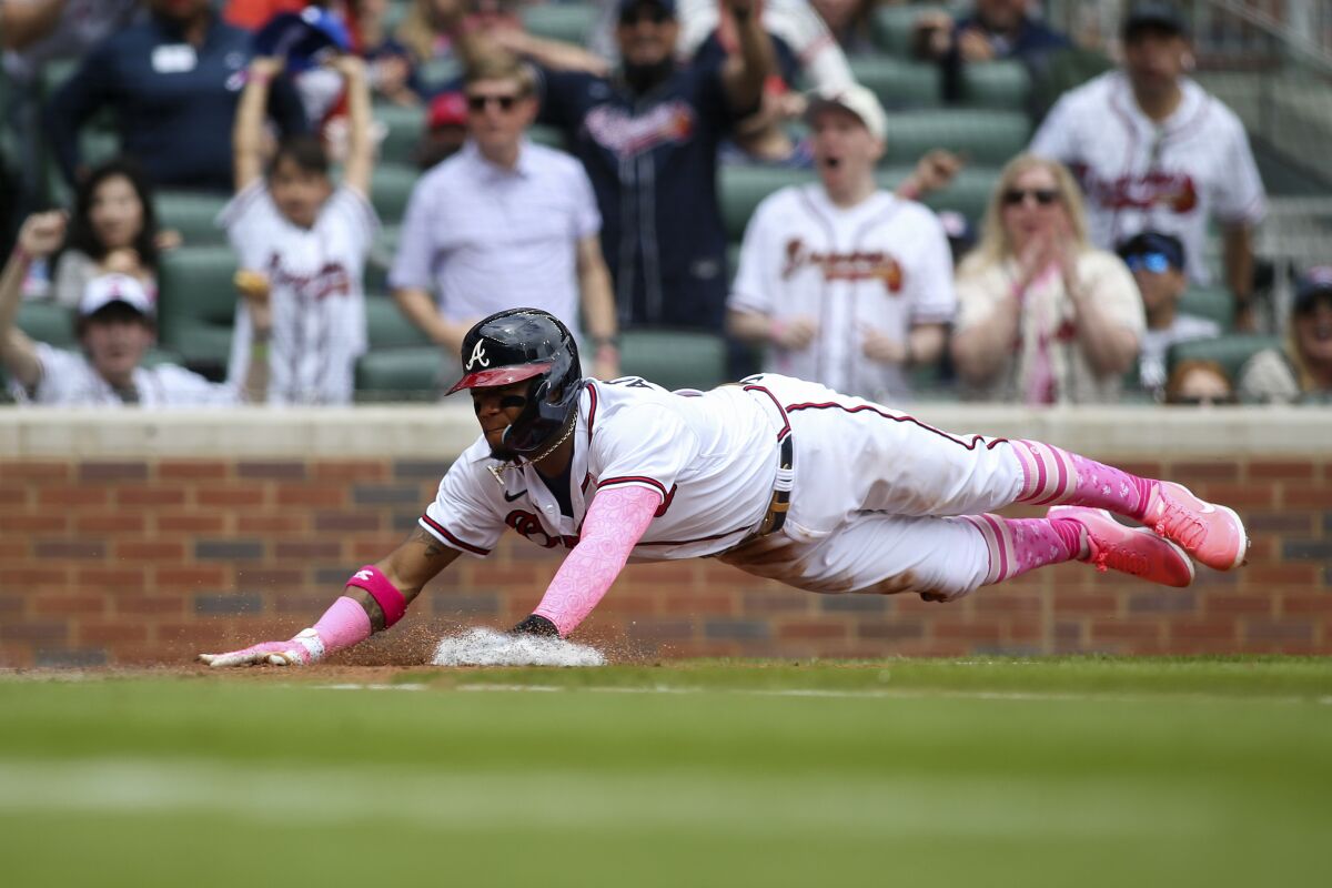 Atlanta Braves' Ronald Acuna Jr. dives home to score a run in the second inning of a baseball game against the Milwaukee Brewers Sunday, May 8, 2022, in Atlanta. (AP Photo/Brett Davis)