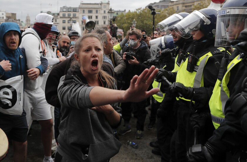 A protester holds out her hand and yells at a line of riot police in Trafalgar Square in London on Saturday.