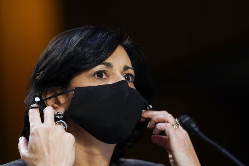 Dr. Rochelle Walensky adjusts her face mask during a Senate hearing.