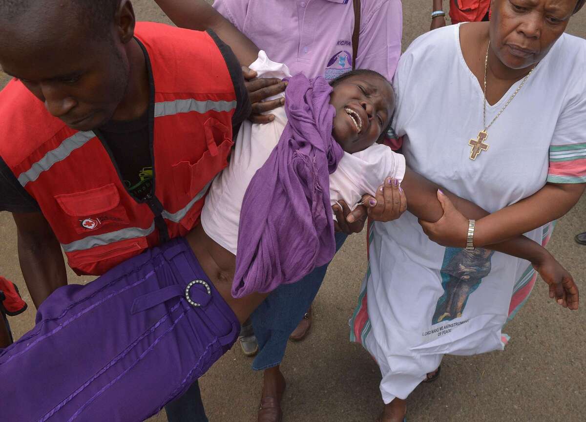 Kenyan Red Cross workers assist a woman overcome with grief Friday after seeing the body of a relative killed by Somalia's Shabab Islamic extremists at Garissa University College a day earlier.