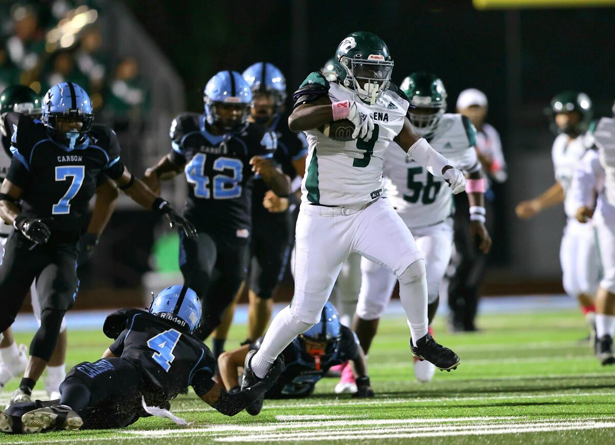 Gardena running back Xavier Grant slips past would-be tacklers during a game against Carson.