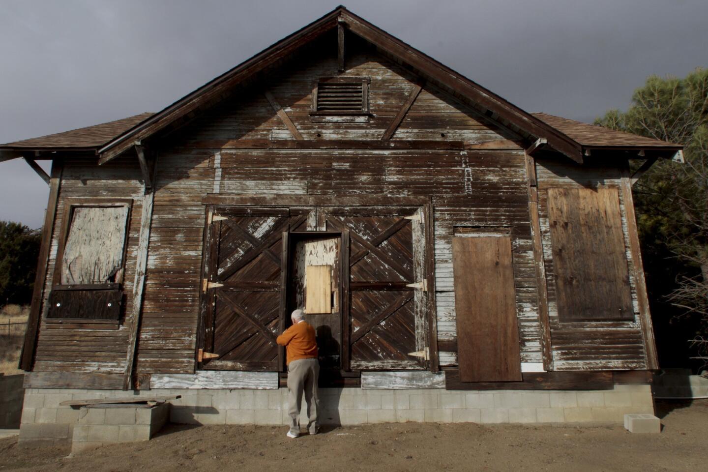 John Seymour of the West Antelope Valley Historical Society unlocks the Old Leona Valley Schoolhouse. Built a century ago, its inside is gutted, but its floor plan and design remain mostly intact.