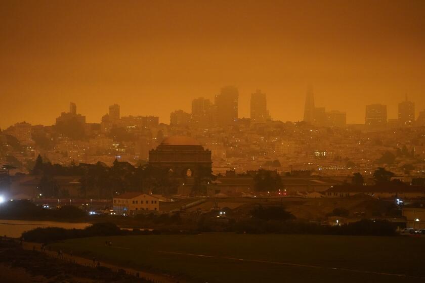 FILE - In this Sept. 9, 2020, file photo, taken at 11:18 a.m., is a dark orange sky above Crissy Field and the city caused by heavy smoke from wildfires in San Francisco. Wildfires that scorched huge swaths of the West Coast churned out massive plumes of choking smoke that blanketed millions of people with hazardous pollution that spiked emergency room visits and that experts say could continue generating health problems for years. An Associated Press analysis of air quality data shows 5.2 million people in five states were hit with hazardous levels of pollution for at least a day. (AP Photo/Eric Risberg, File)
