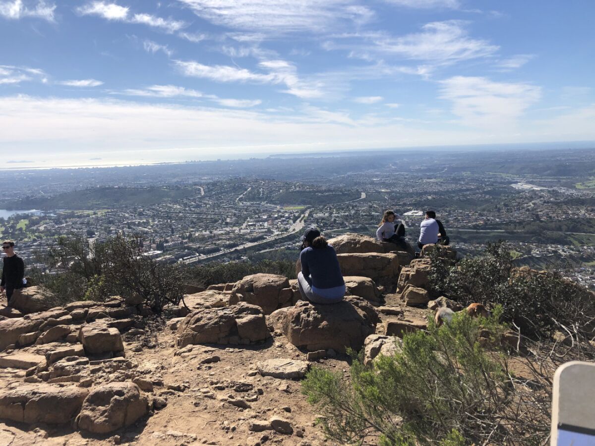 Hikers on the summit of Cowles Mountain, San Diego's highest point, relax and enjoy the view, which sometimes includes Tijuana.