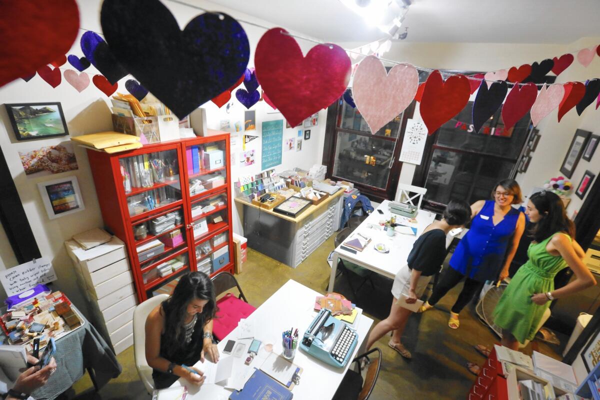 Megan Johnson, left, of Los Angeles, writes a letter to her mom, who lives in North Carolina, at a gathering of the L.A. Penpal club at Paper Pastries Atelier in downtown Los Angeles.