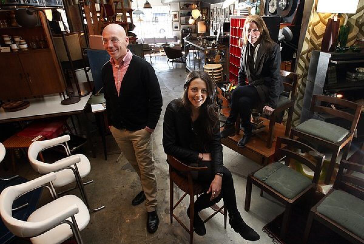 The partners behind the new vintage store Shopclass in Highland Park are Jeff Garbs, Sally Breer, center, and Ellen LeComte. To the left are 1970s white vinyl and chrome armchairs; to the right are Martin Visser chairs with seats reupholstered in vintage military tent material.