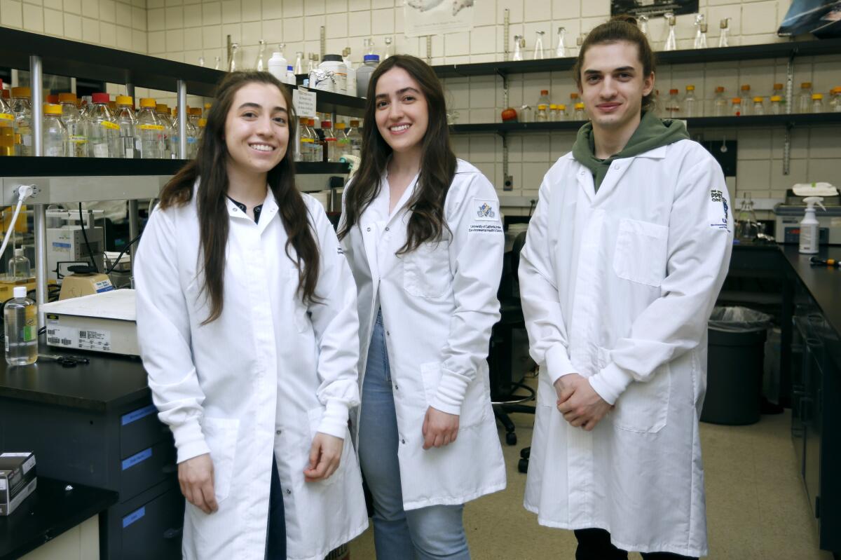 Siblings Wedad, 25, left, Lamees, 26, center, and Sammy Alhassen, 23, pose for a photo in a UC Irvine laboratory on Thursday.
