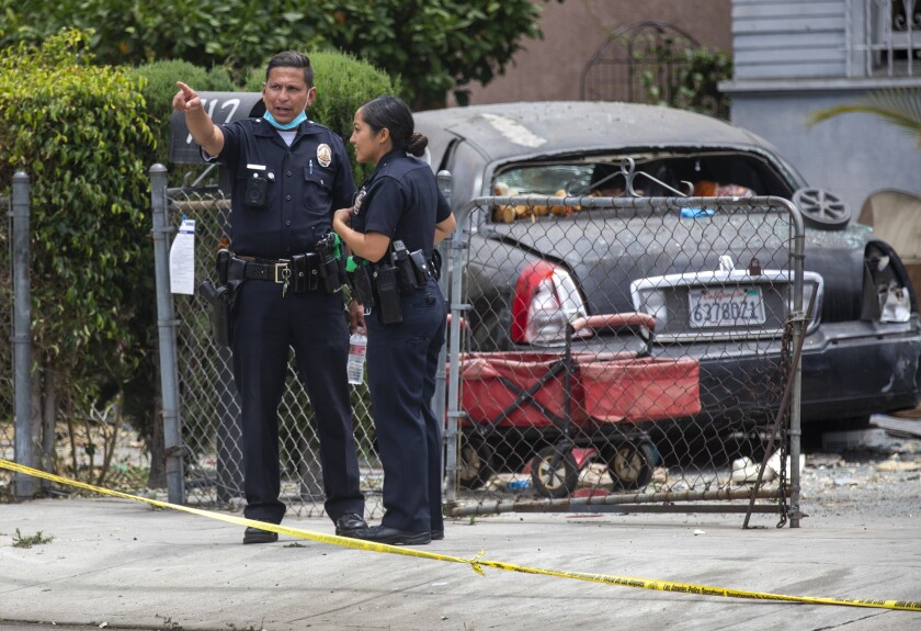 Two police officers. One has a mask around his neck