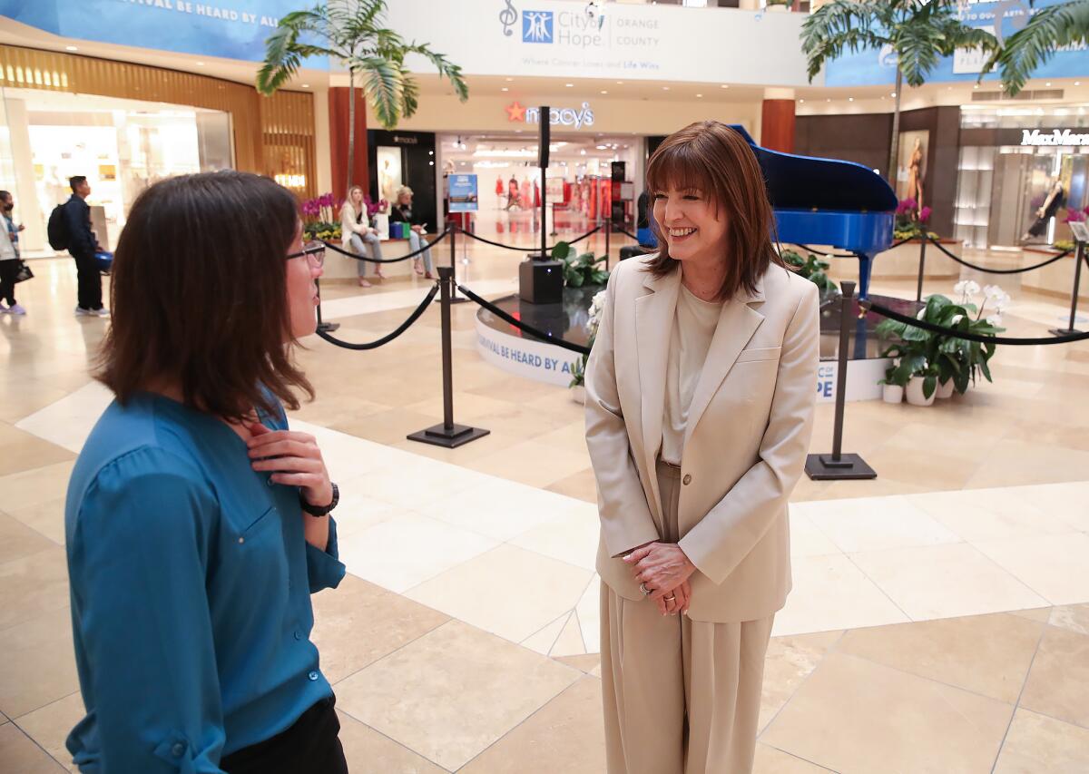 Laura Weiss from Pacific Symphony and Michele Vacca chat at South Coast Plaza on Monday.