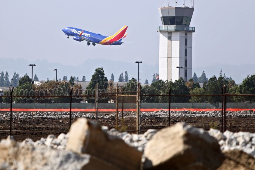 A commercial airliner takes off at the Avion Burbank project, a mixed-used industrial park north of the Hollywood Burbank Airport, that is planned to have 18 buildings, during ground breaking ceremony by Overton Moore Properties, in Burbank on Wednesday, Oct. 9, 2019.