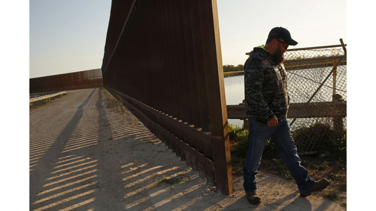 Robert Cameron stands on the south side of the border fence in Progreso Lakes, where he does tours for people who want to see the border area.