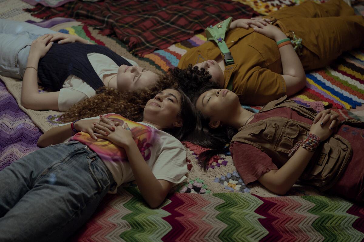 Four girls lying on the floor at a sleepover