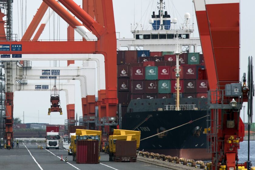FILE - A crane prepares to unload a container from a semi-trailer truck at the Aomi wharf in Tokyo on Sept. 17, 2021. Japan’s economy contracted less than previously thought in the last quarter, according to revised data released Thursday, Dec. 8, 2022. (AP Photo/Hiro Komae, File)