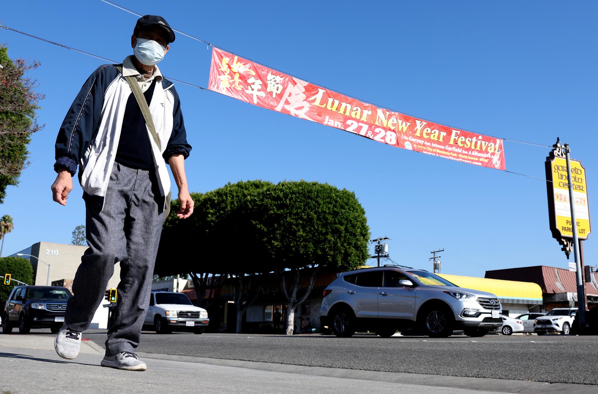 A pedestrian walks by a banner promoting the Lunar New Year Festival 