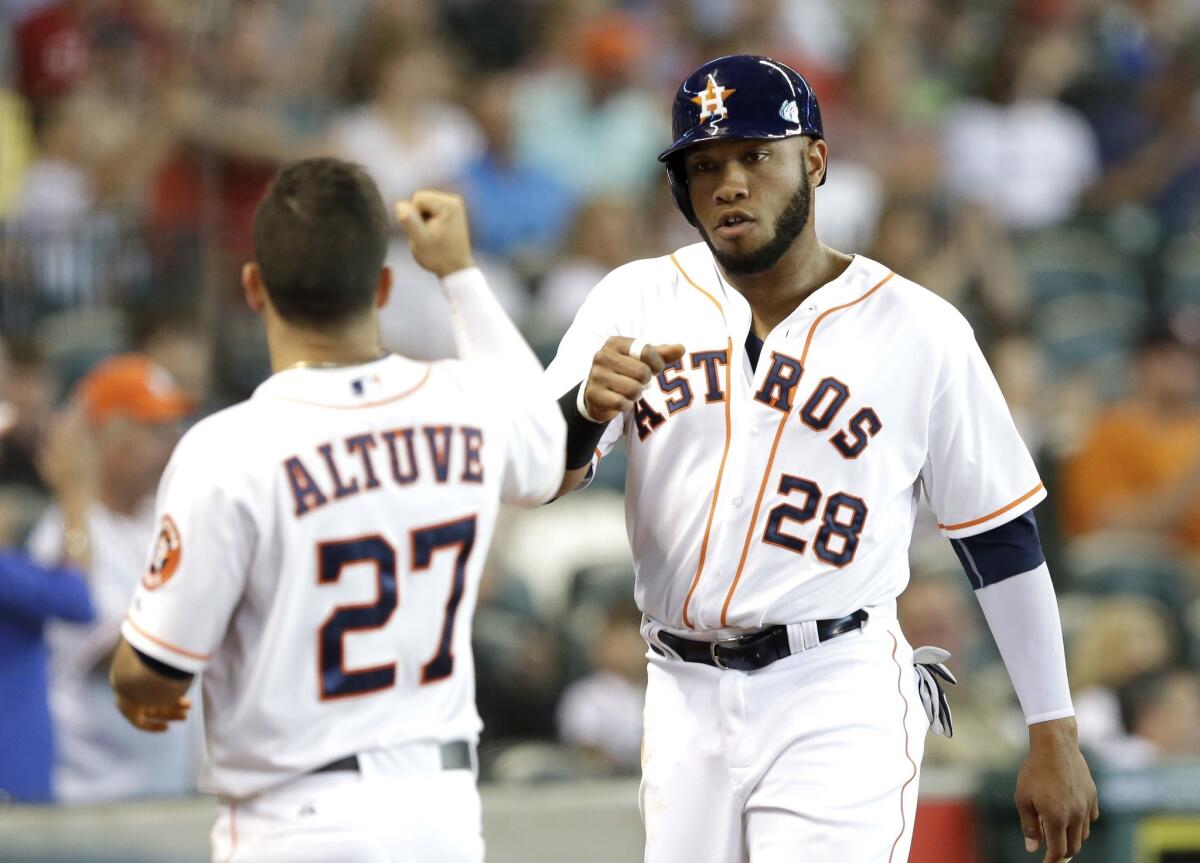 Jon Singleton, right, is met by Jose Altuve, left, after scoring in the fourth inning on a Robbie Grossman bunt. The Astros defeated the Angels, 8-5.