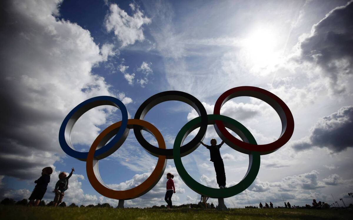 Children play on the Olympic rings at the rowing venue in Eton Dorney, near Windsor, England,
