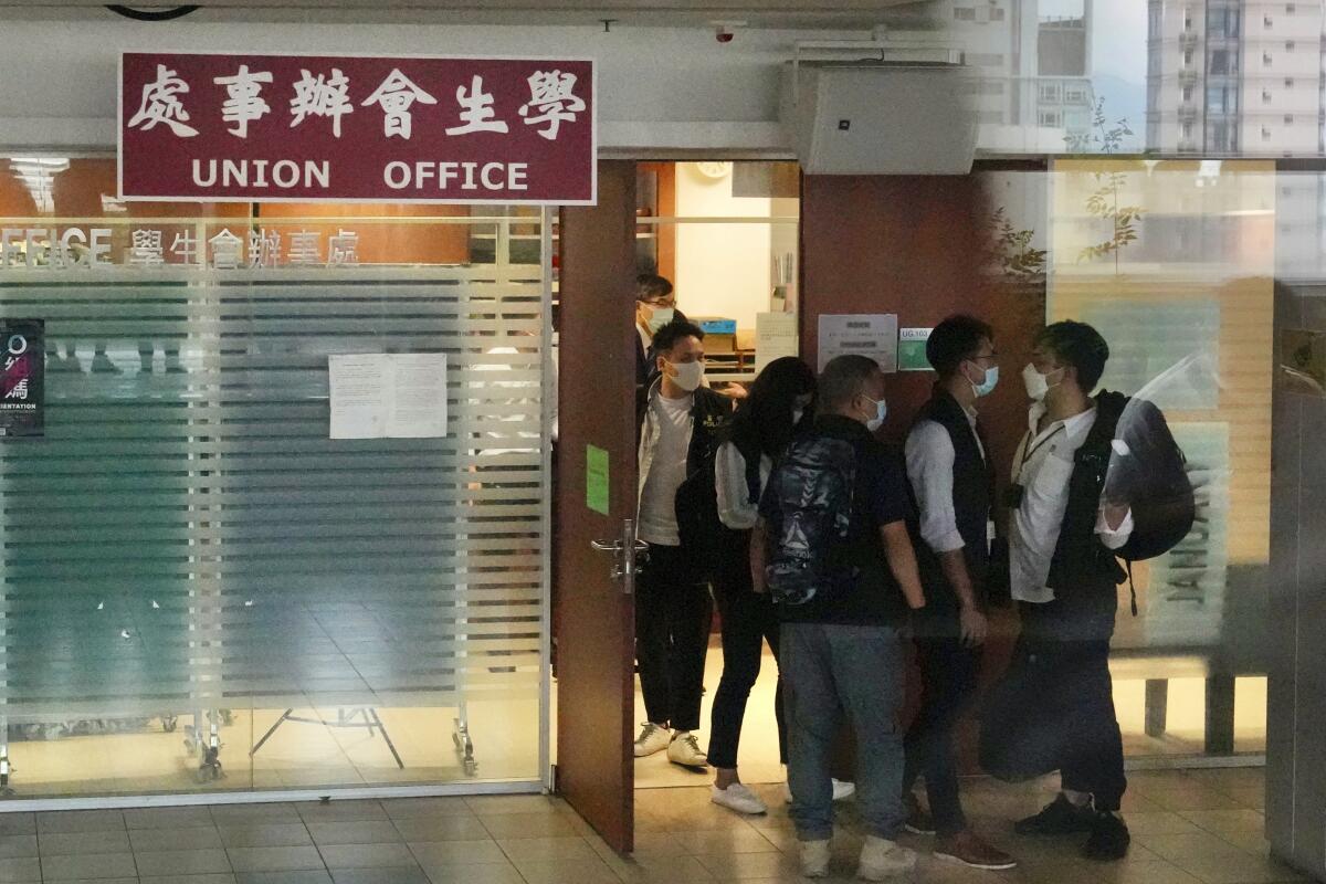 Police officers gather at the office of student union in campus of the University of Hong Kong, Friday, July 16, 2021. Hong Kong's national security police on Friday raided the office after student leaders last week commemorated the death of an attacker who killed himself after stabbing a police officer. (AP Photo/Kin Cheung)