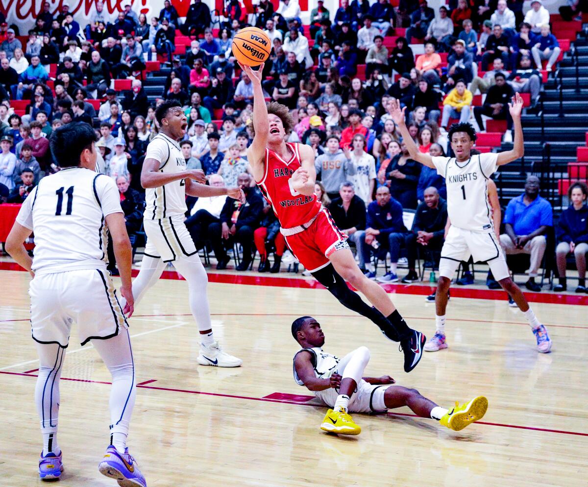 Harvard-Westlake's Trent Perry tries to score on a layup over a fallen defender.