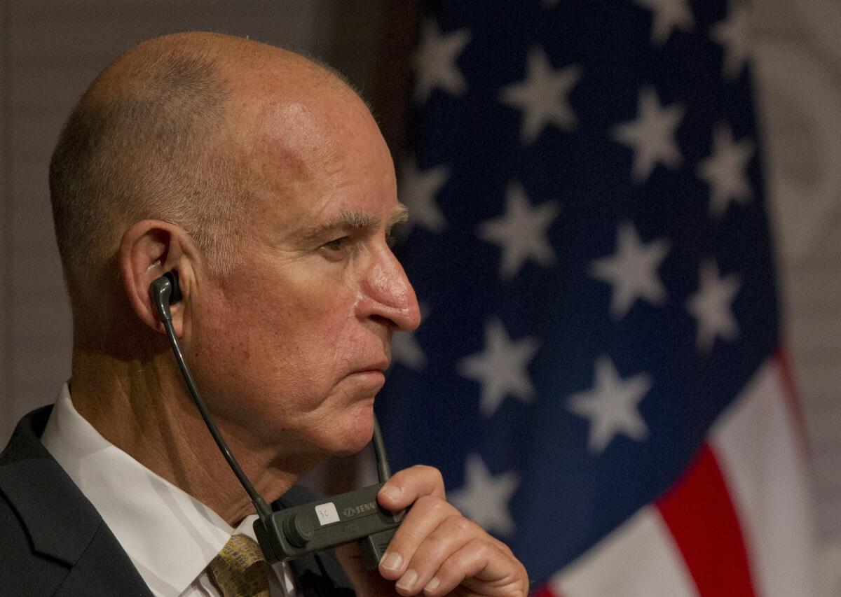 California Gov. Jerry Brown listens to a translation over headphones during his trip to Mexico last month. On Wednesday, he struck a populist chord in a speech to school employees.