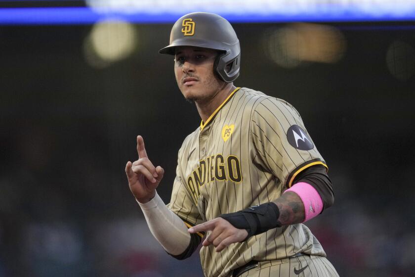 San Diego Padres' Manny Machado gestures at first base after singling during the third inning of the team's baseball game against the Los Angeles Angels in Anaheim, Calif., Tuesday, June 4, 2024. (AP Photo/Eric Thayer)