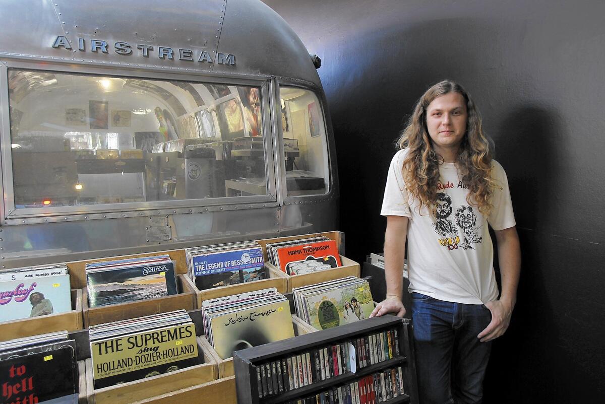Parker Macy stands outside his Creme Tangerine vinyl records store in an Airstream trailer at The Lab in Costa Mesa. The store will throw a fifth-anniversary party Friday.