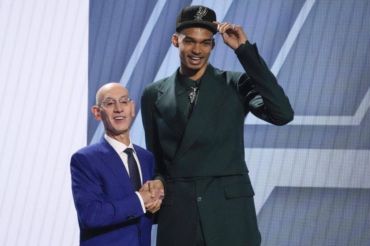 Victor Wembanyama poses for a photo with NBA commissioner Adam Silver after being selected first overall by the Spurs.