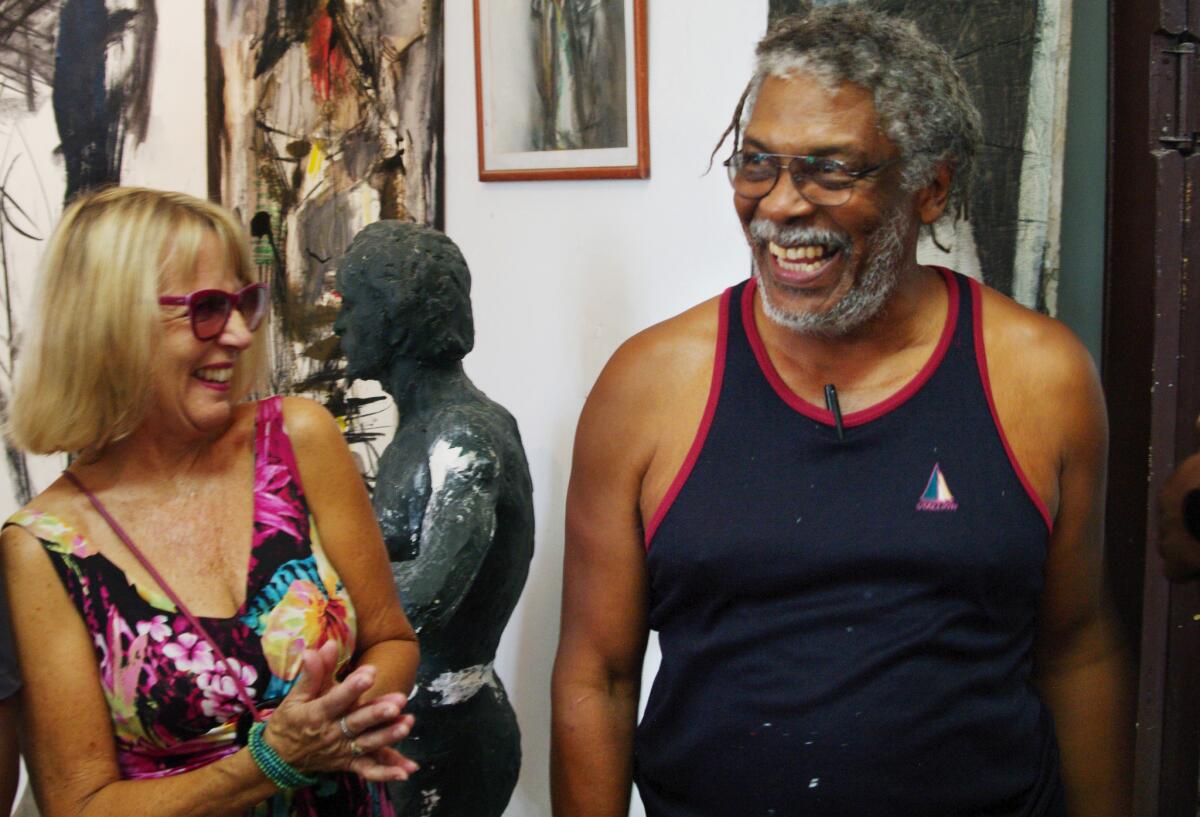 Cuban artist Alberto Lescay at his workshop with Nancy Covey, who brought a group of U.S. visitors to Cuba to explore the country's music and art scene. (Randy Lewis / Los Angeles Times)