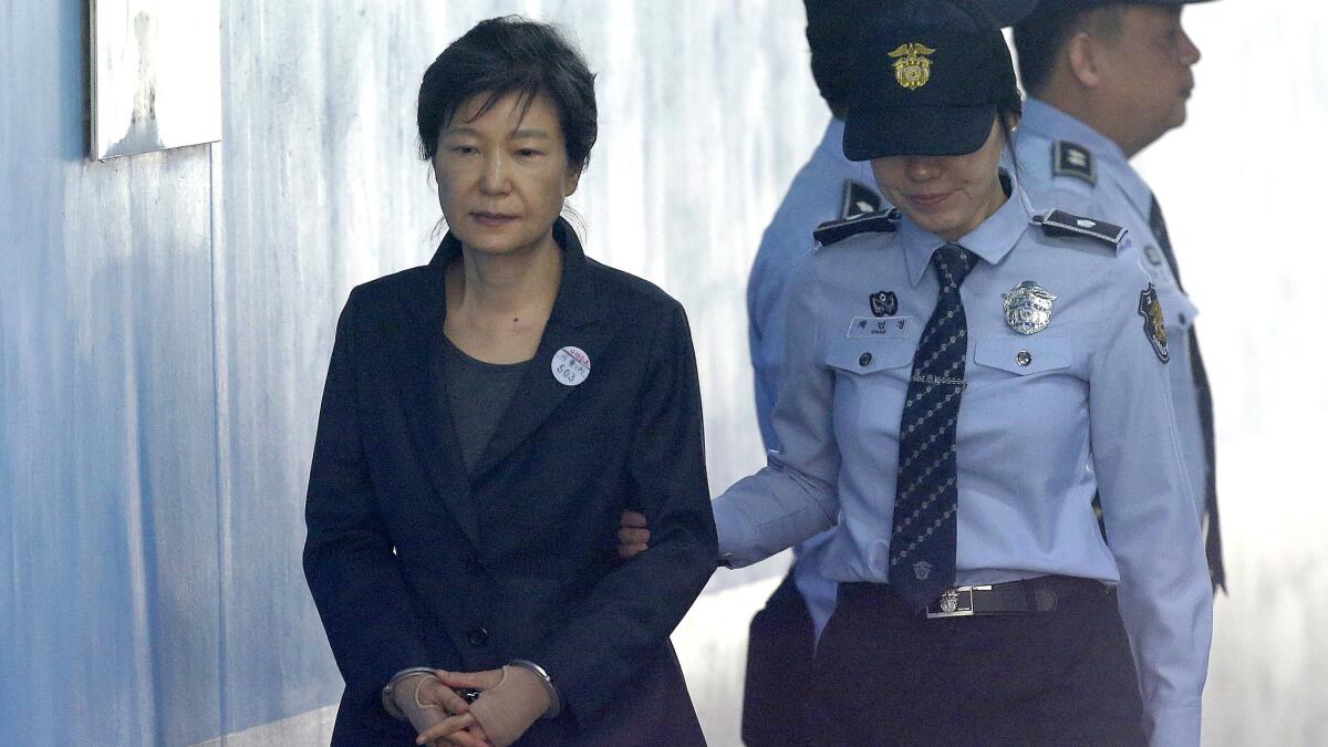 Former South Korean President Park Geun-hye, left, arrives to attend a hearing on the extension of her detention at the Seoul Central District Court on Oct. 10, 2017.