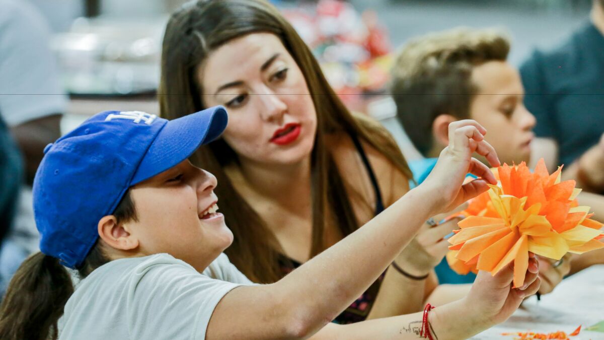 Shantal Verduzco, right, helps Isabel Fort, 10, make art during a youth workshop held at Self Help Graphics in Boyle Heights.