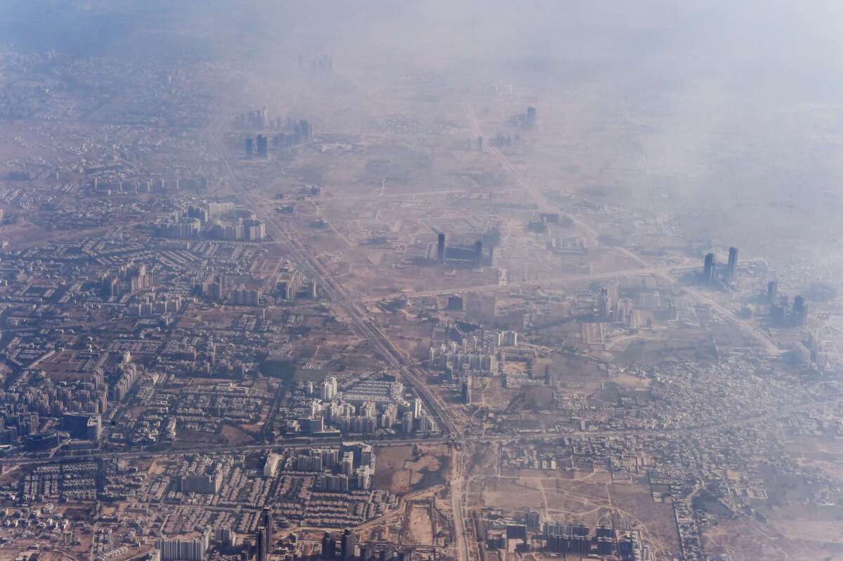 Smog envelops buildings on the outskirts of India's capital city of New Delhi on Nov. 25, 2014.