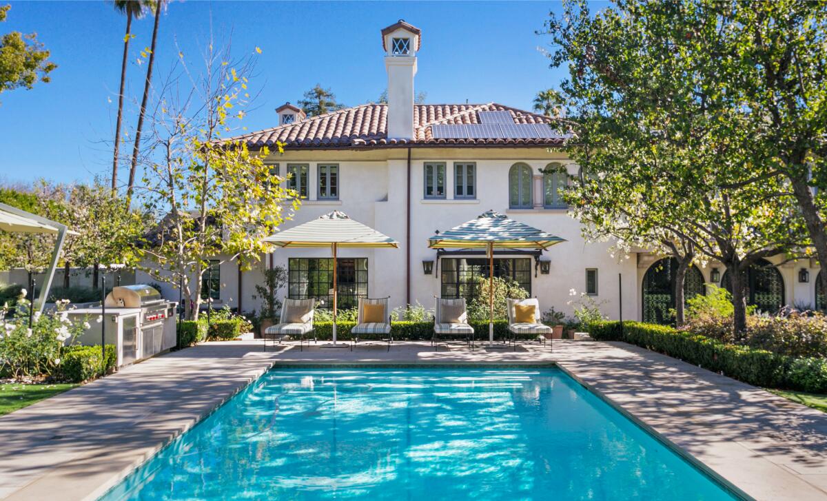 This photo shows a two-story house with pool