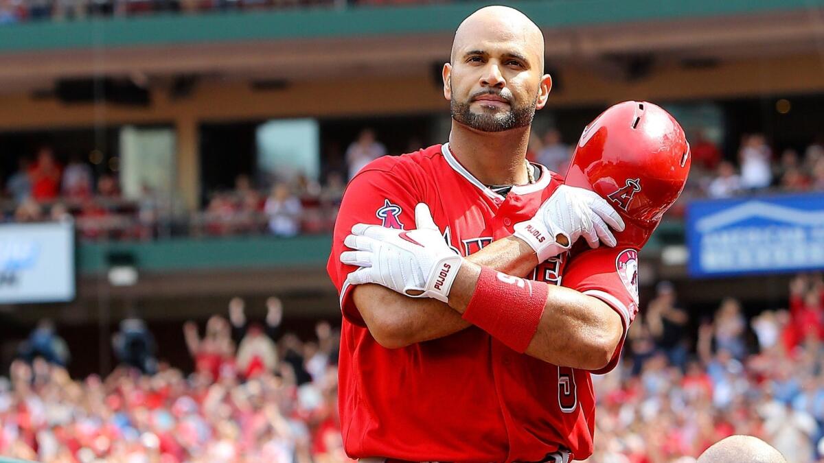 Albert Pujols pops out of the dugout to acknowledge the fans after hitting a solo home run in the seventh inning Saturday in St. Louis.