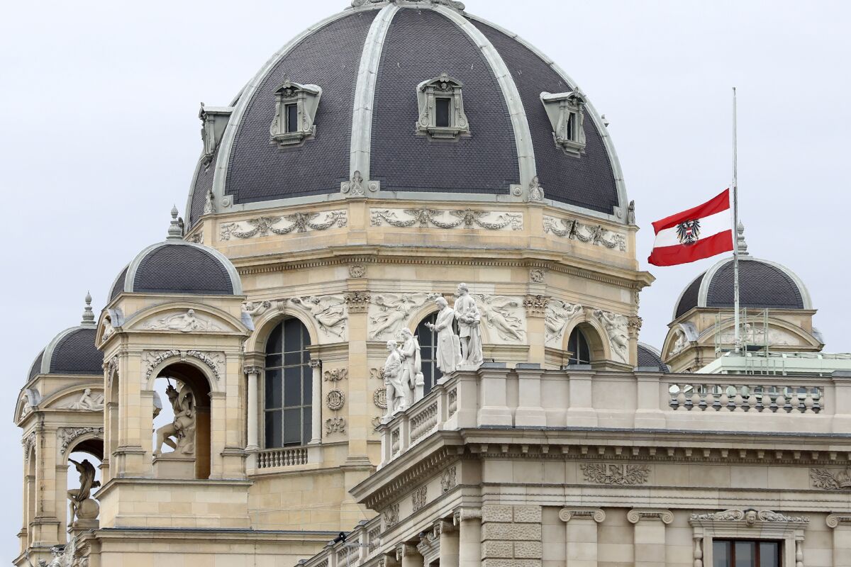 The Austrian national flag waves of half-mast on a building downtown in Vienna, Austria, Wednesday, Nov. 4, 2020. Several shots were fired shortly after 8 p.m. local time on Monday, Nov. 2, in a lively street in the city center of Vienna. (AP Photo/Matthias Schrader)
