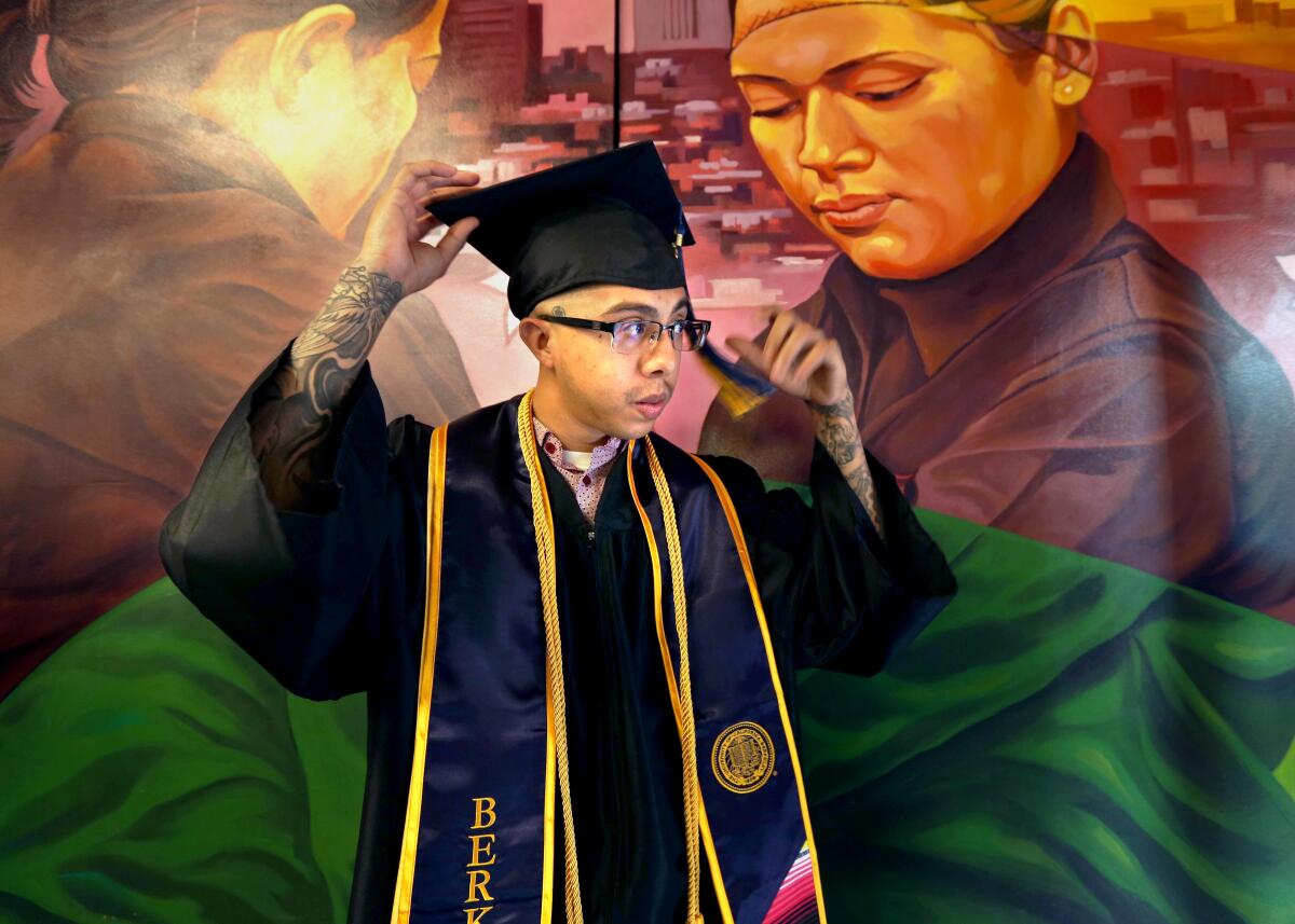 A man strikes a pose in a cap and gown