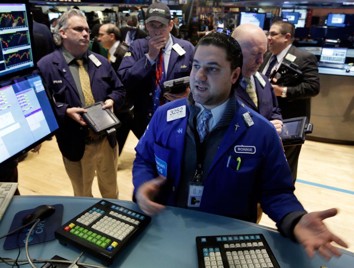 Ronnie Howard, center, works at the post that trades CVS Caremark on the floor of the New York Stock Exchange this week.