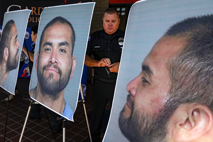 Charles Starnes stands among photographs Wednesday of Zachary Castaneda, the suspect in a deadly rampage in Orange County. Castaneda, of Garden Grove, is accused of stabbing four people to death. 