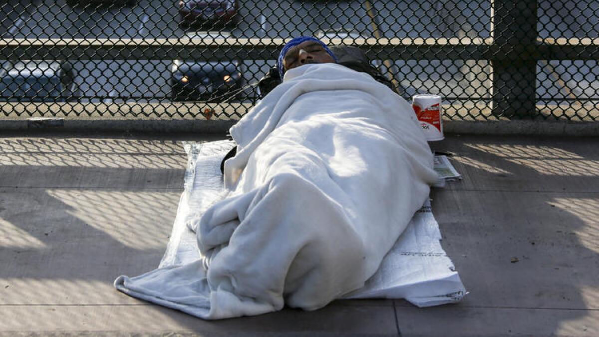 A homeless man sleeps on a bridge over Main Street in downtown Los Angeles.