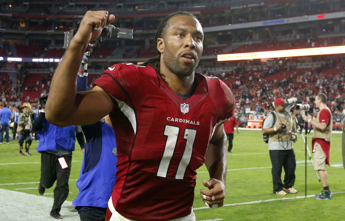 Cardinals wide receiver Larry Fitzgerald pumps his fist as he runs off the field after beating the Bengals, 34-31.