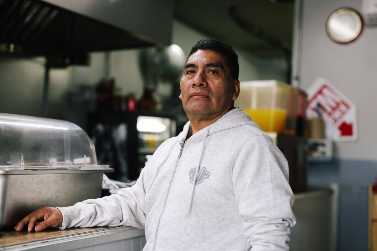 A taquería restaurant owner stands in the kitchen of his business in Anaheim. 