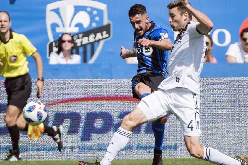 L.A. Galaxy's Dave Romney, right, challenges Montreal Impact's Alejandro Silva during first-half MLS soccer game action in Montreal, Monday, May 21, 2018. (Graham Hughes/The Canadian Press via AP)