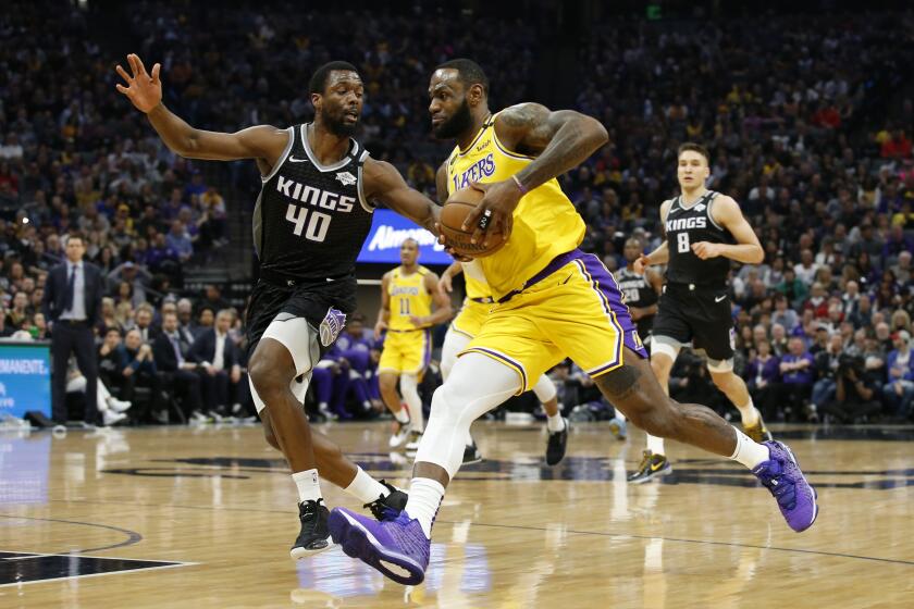 Los Angeles Lakers forward LeBron James, right, drives against Sacramento Kings forward Harrison Barnes during the first quarter of an NBA basketball game in Sacramento, Calif., Saturday, Feb. 1, 2020. (AP Photo/Rich Pedroncelli)