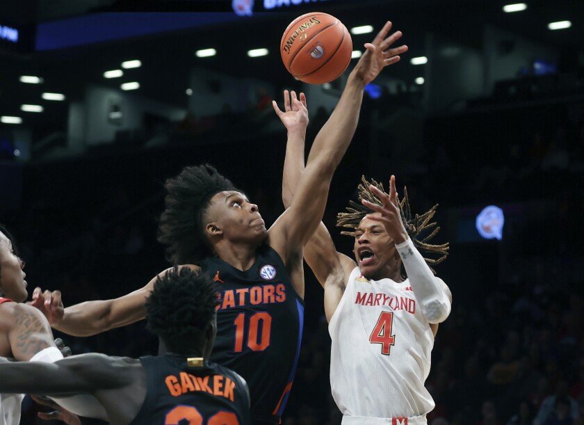 Maryland's Fatts Russell (4) has the ball knocked away by Florida's Elijah Kennedy (10) during the first half of an NCAA college basketball game Sunday, Dec. 12, 2021, in New York. (AP Photo/Jason DeCrow)