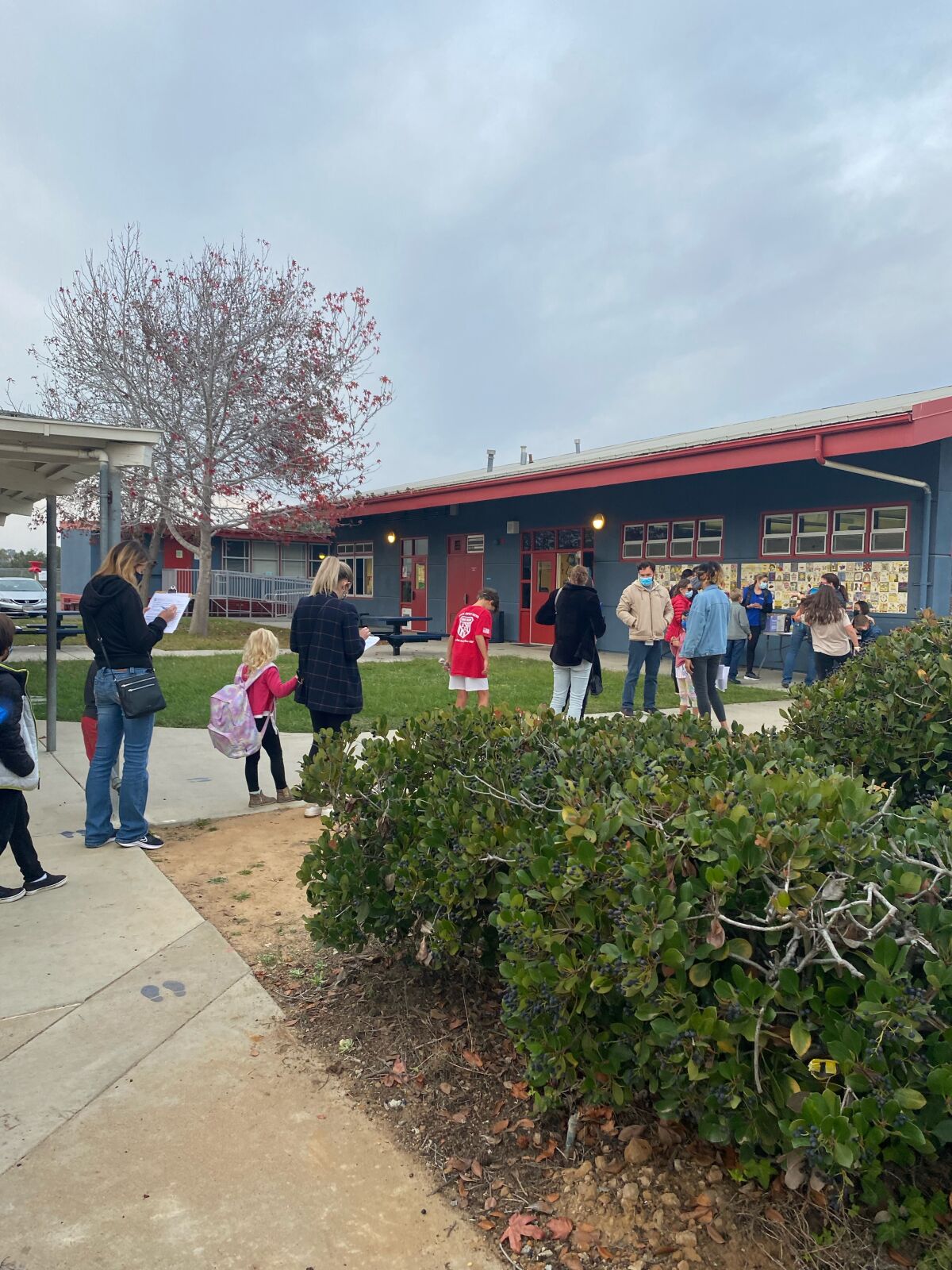 Parents and students wait at Torrey Pines Elementary School's COVID-19 and flu vaccination clinic Dec. 6
