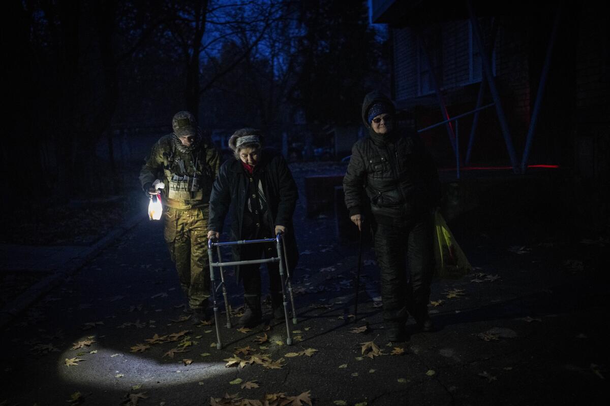 Elderly residents using walkers are evacuated from the southern city of Kherson, Ukraine, during the night.