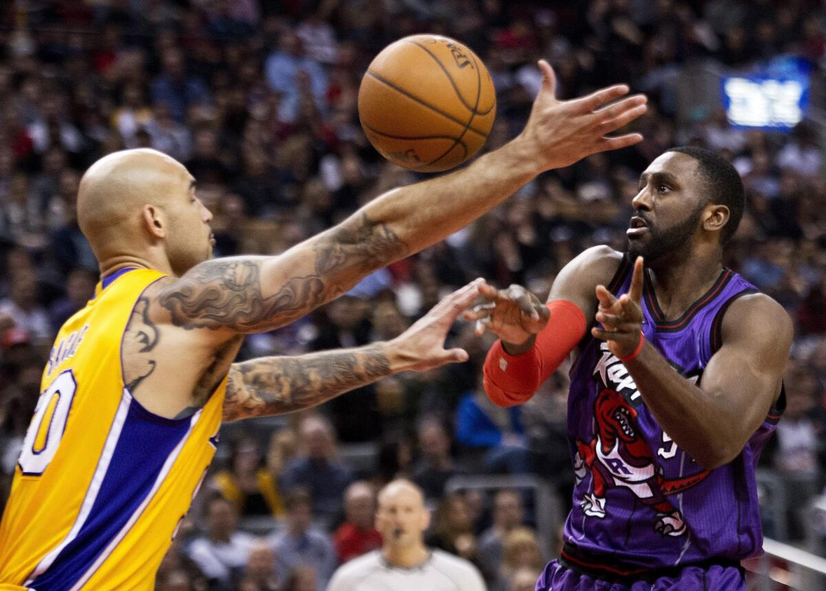 Lakers center Robert Sacre tries to get to a rebound before Raptors forward Patrick Patterson in the first half.