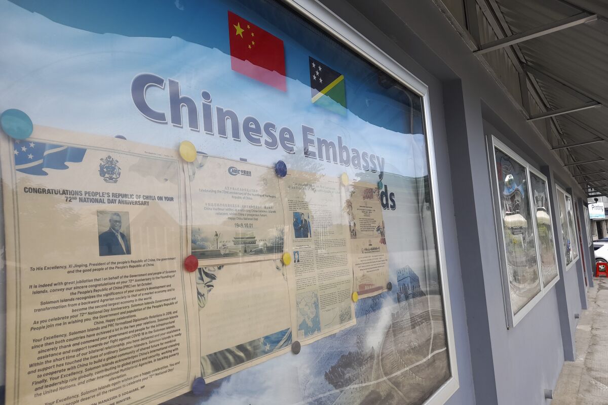 FILE - A display case of photos is seen outside the Chinese Embassy in Honiara, Solomon Islands, April 2, 2022. Australia’s Minister for International Development and the Pacific Zed Seselja flew to the Solomon Islands on Tuesday, April 12, 2022, in a bid prevent a China military presence in the South Pacific Island nation.(AP Photo/Charley Piringi, File)
