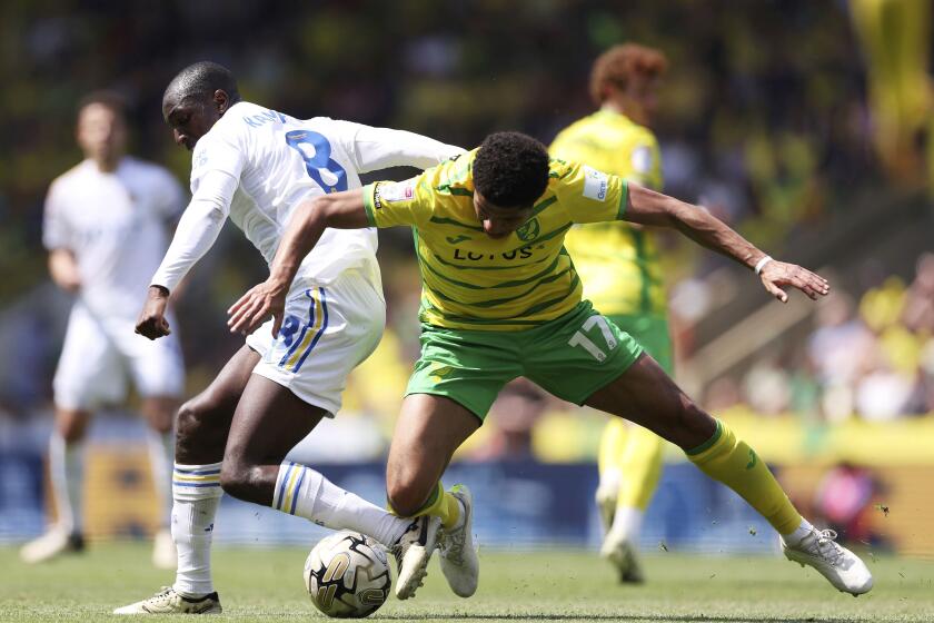 Leeds United's Glen Kamara, left, vies for the ball with Norwich City's Jonathan Rowe, during the English Football League Championship playoff, semi-final, first leg soccer match between Norwich and Leeds United, at Carrow Road, Norwich, England, Sunday May 12, 2024. In the race to secure the last promotion spot for the Premier League, Norwich and Leeds drew 0-0 in the first-leg of their Championship play-off semifinal on Sunday. (Steven Paston/PA via AP)